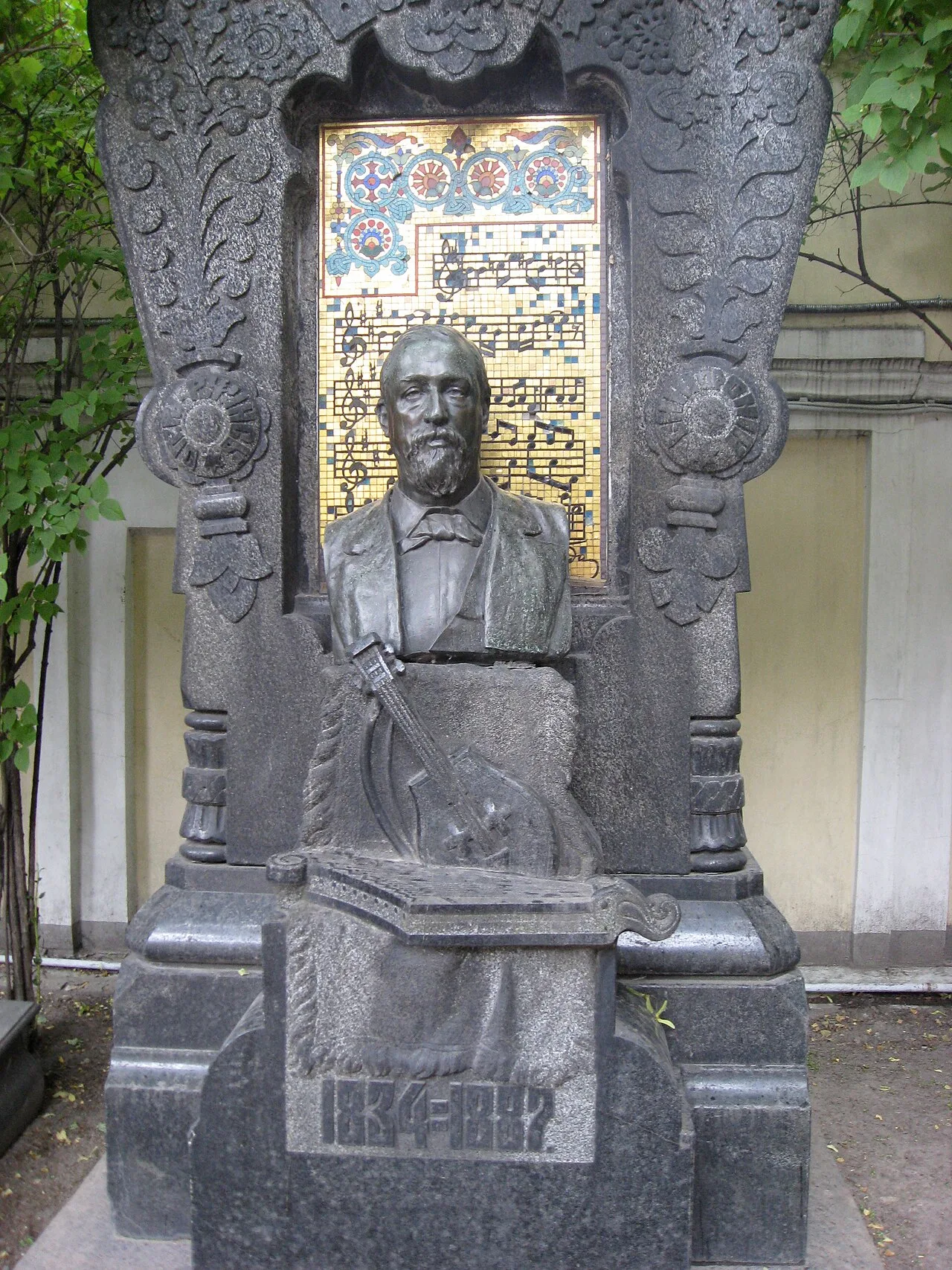 Tomb of Borodin in Tikhvin Cemetery. The musical notation in the background shows themes from Symphony No. 2, the "Glidi