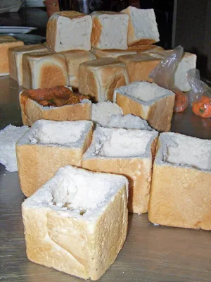 A table of hollowed "quarter loaves" to be filled for bunny chow.