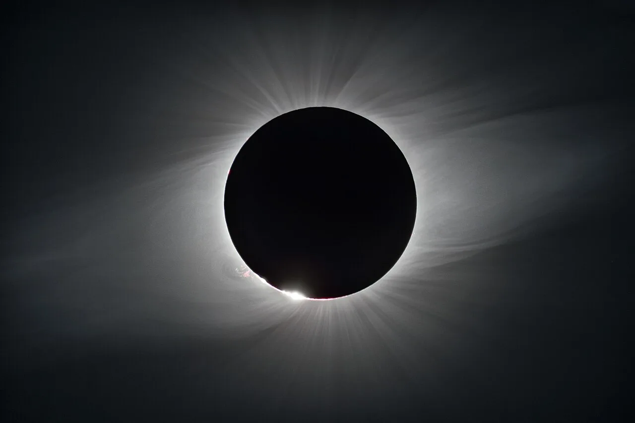 The light visible close to the Sun during a total solar eclipse originates primarily from the K-corona.