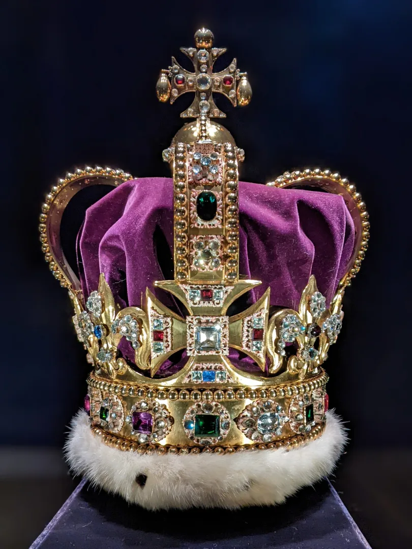 Large gold crown decorated with diamonds and red, green, blue, and purple gemstones