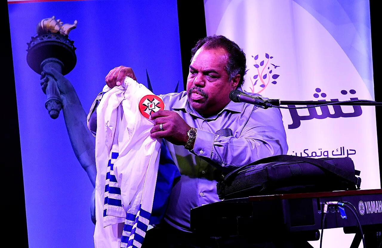 Davis holding up KKK robes at Blues and Rock for Humanity in November 2017