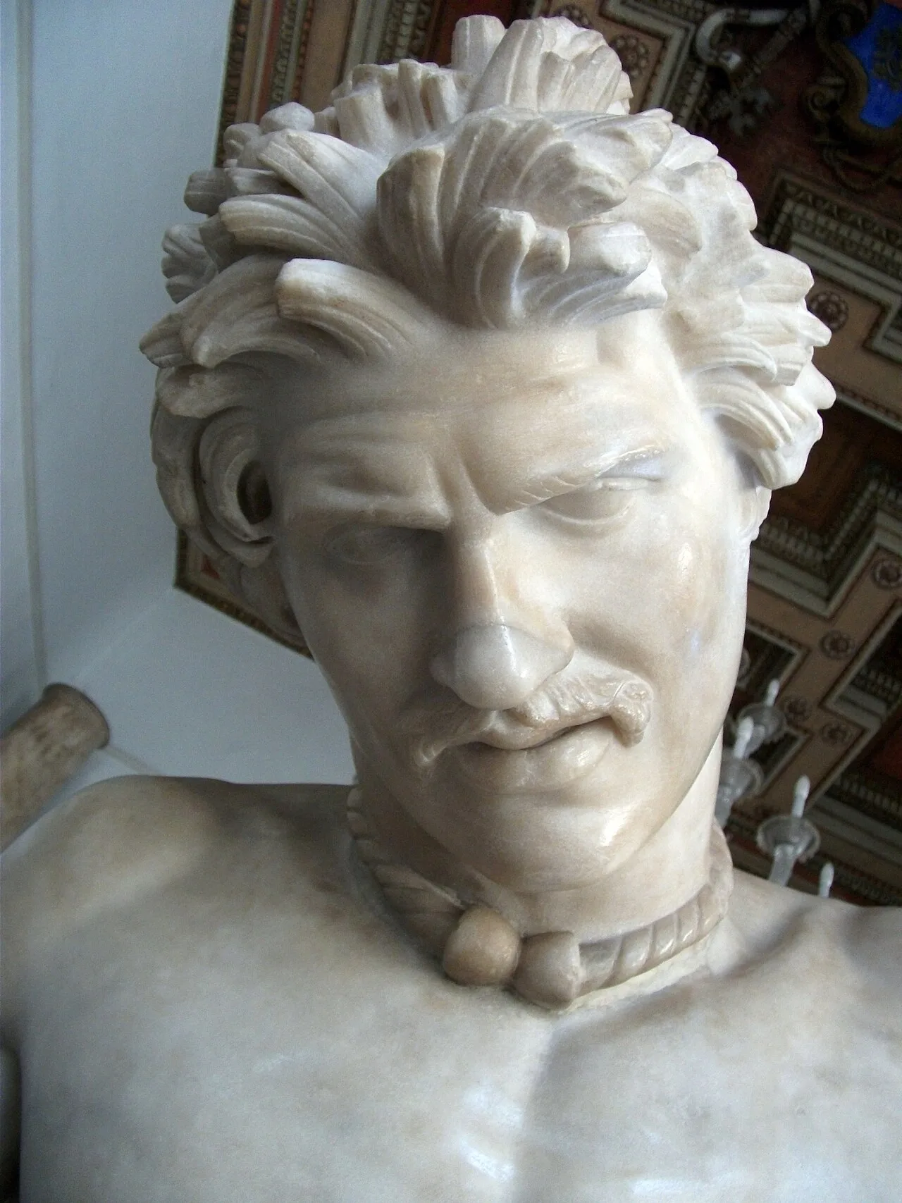 Detail showing the face, hairstyle and torc of the sculpture