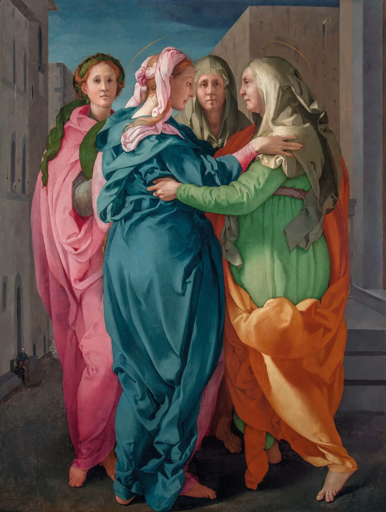 The Virgin Mary, wearing a teal blue dress and a rose-colored scarf in her hair, and St. Elizabeth, wearing a lime green dress and a white veil, embrace on a city street. Both have thin gold halos.