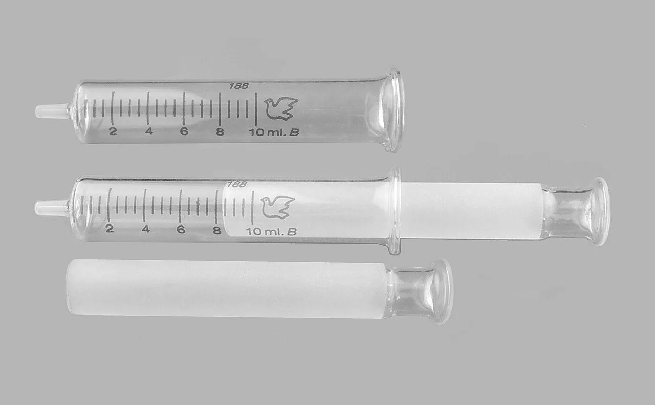 Syringe made entirely of glass, similar to the Wood design, except it is etched with volume marks.
