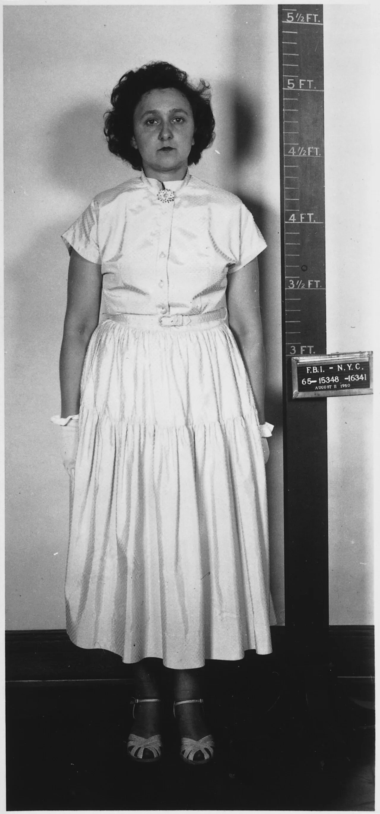 Side- and front-view portrait photographs of woman wearing white apparel. The woman has thick, black, curly hair and maintains an emotionless face