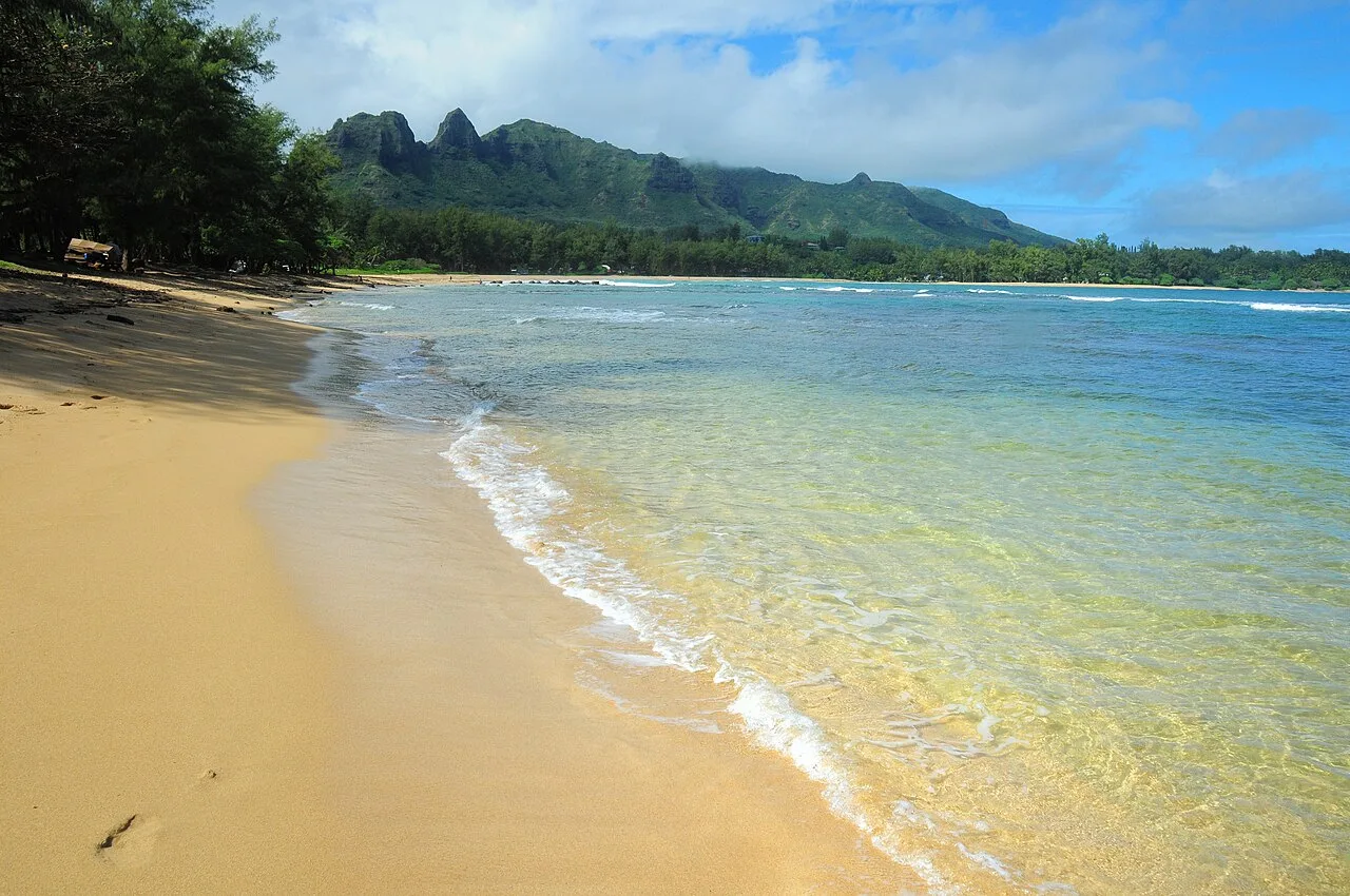 Anahola Bay is a snorkeling and swimming beach with clear pools and a long coral reef.
