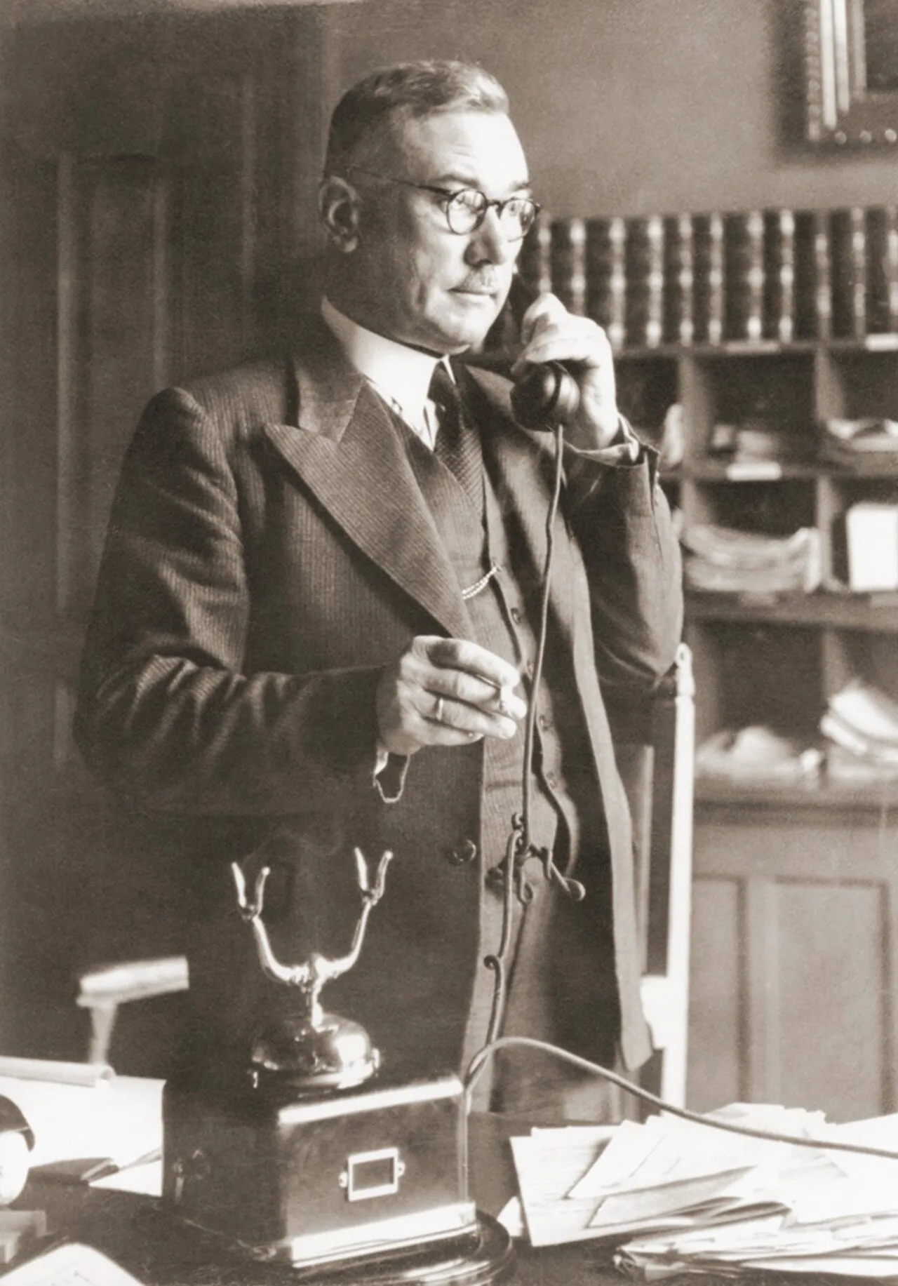 A photograph of Josef Hoop standing while on the telephone in 1945.