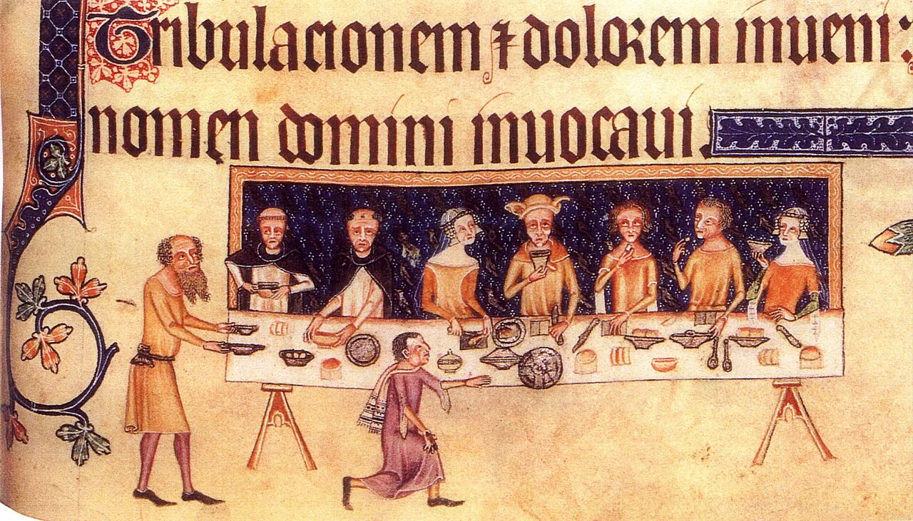 Sir Geoffrey Luttrell at table surrounded by his family and two Dominican friars. Two servants wait on them and others a