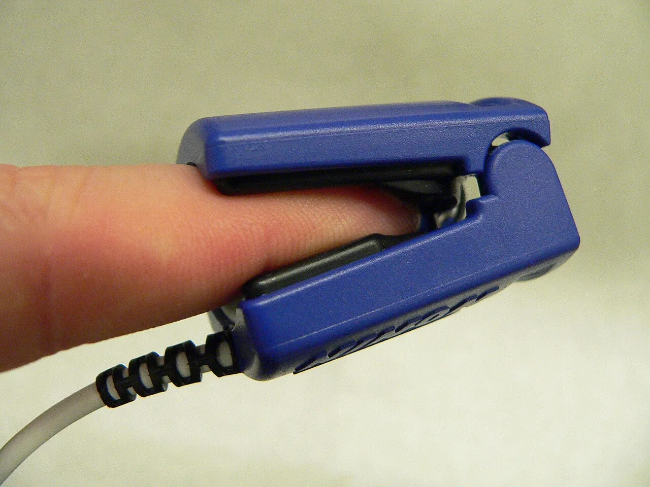 A pulse oximeter probe applied to a person's finger