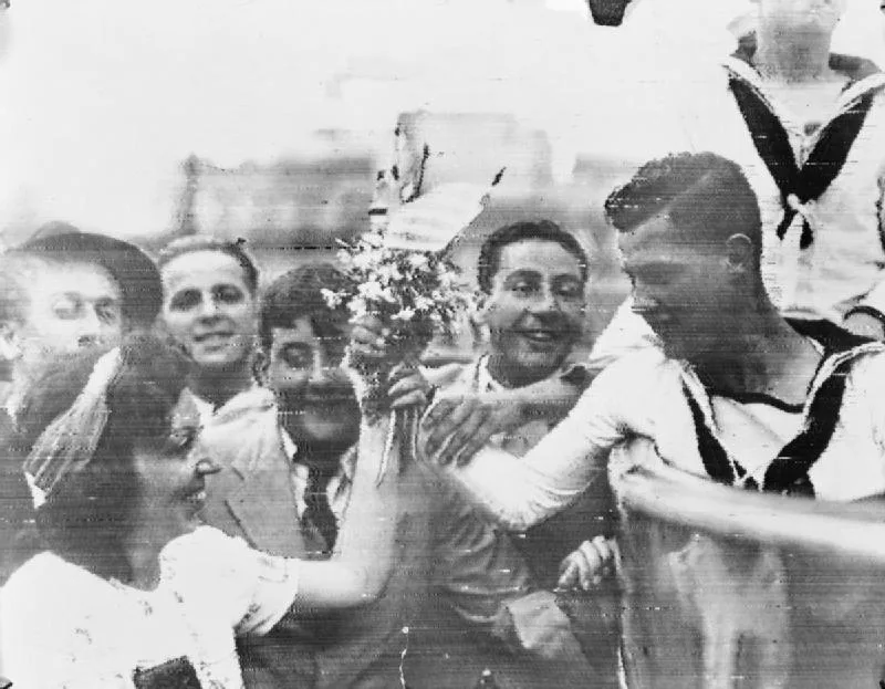 Uruguayan woman presenting flowers to sailors from HMS Ajax .